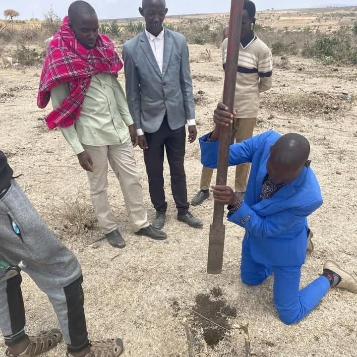 Men setting a timber post into the ground for a new church