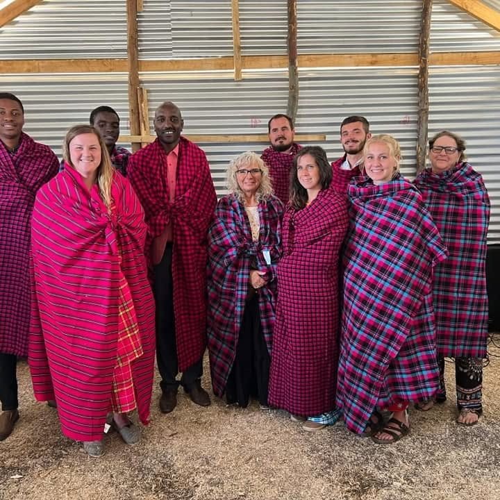 Mission team members and villagers wrapped in traditional Maasai shukas