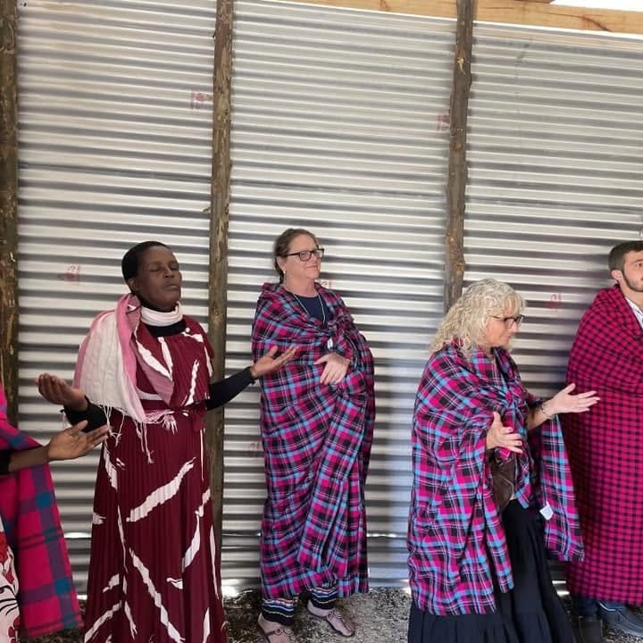 Maasai women and mission team members praying together